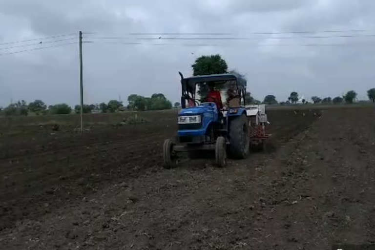 Farmers are sowing the crop with a raised bed planter