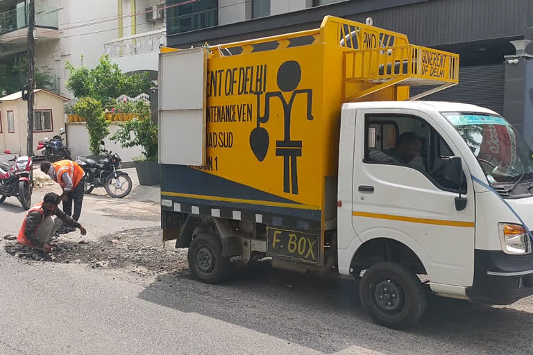 pwd filling pothole in preet vihar using broken road pieces