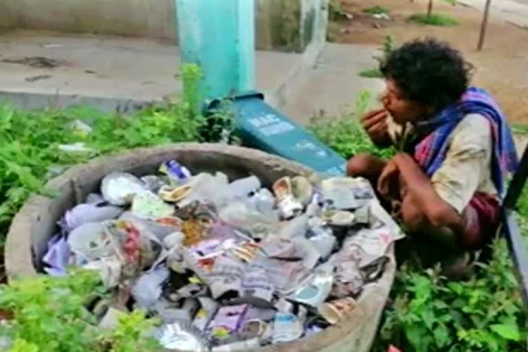 man eating food from dustbin in odisha