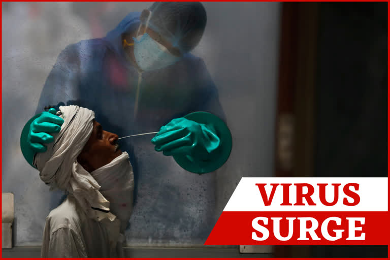 A health worker takes a nasal swab of a person for a COVID-19 test at a hospital in New Delhi.