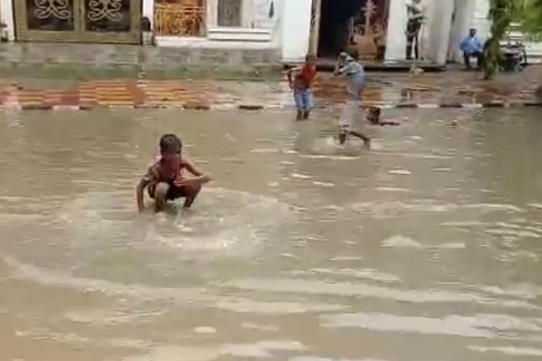 Road becomes a pond, children are seen floating