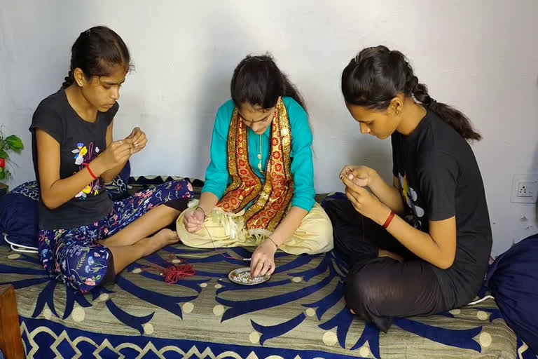 Sisters preparing rakhi at home