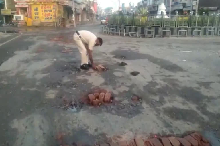 Policeman filling pit created after rain in charkhi dadri