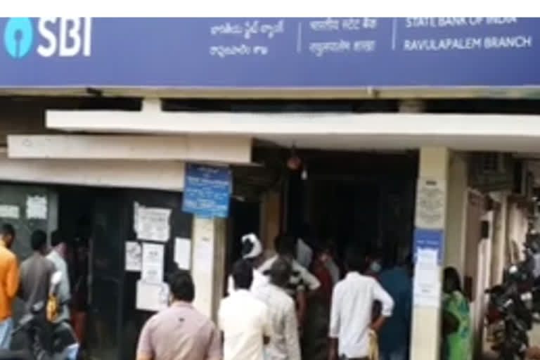 people waiting at front  of bank in ravulapalem