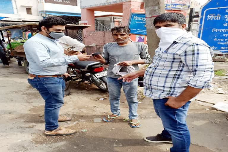 Gannaur Municipality employees distribute masks to people walking without masks