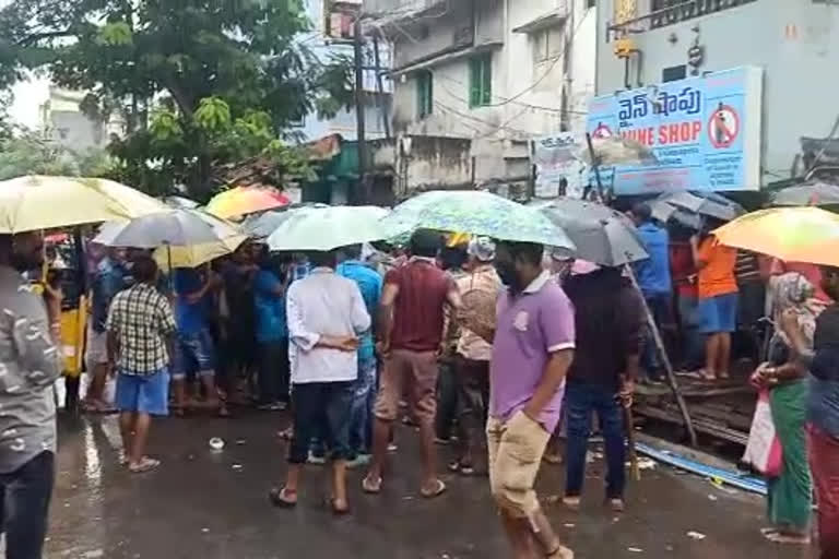 drunkers stood for liquor at Visakha Poornamarket even in the rain