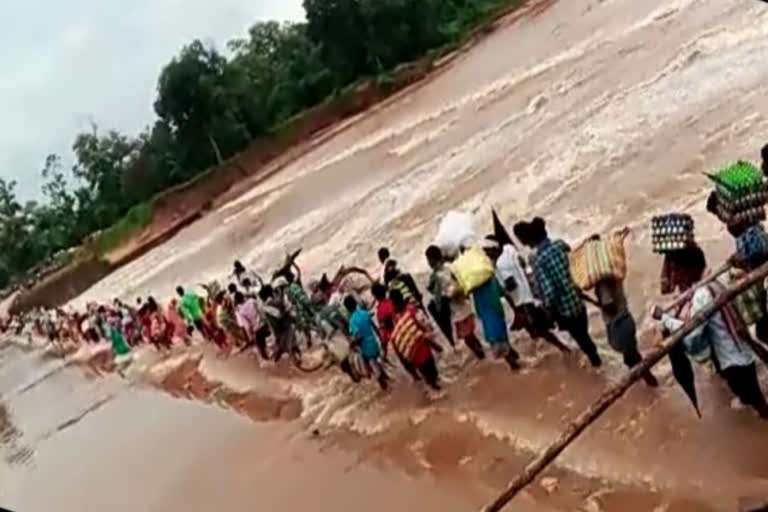 Villagers crossing the overgrown medhaki River