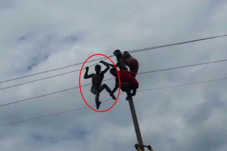 young man climbed on the electric pole