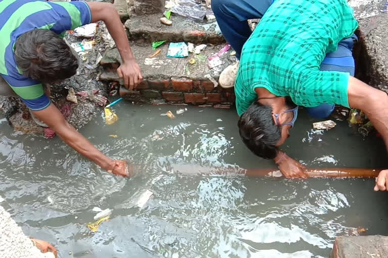 mcd sanitation workers cleaning drainage at rohini zone in delhi