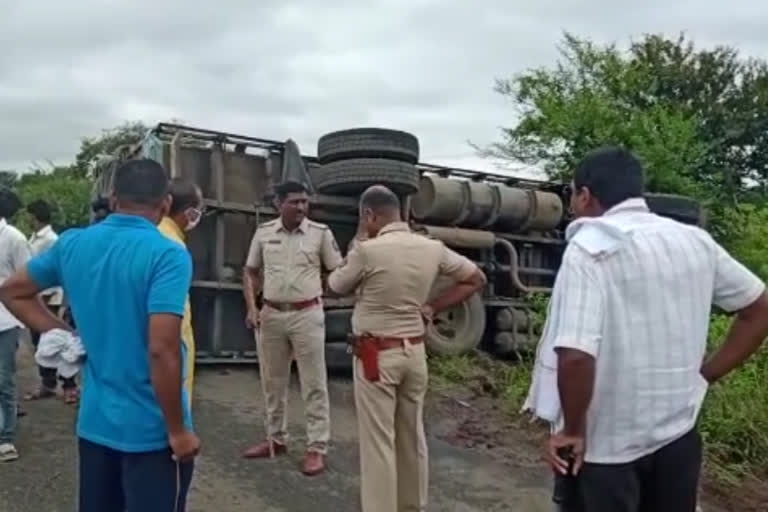 उलटलेल्या ट्रकची पाहणी करताना पोलीस पथक