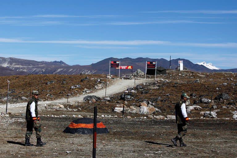 Indian army soldiers walk along the line of control at the India- China border