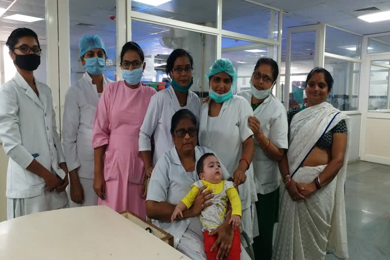 nurses nourishing eight month baby as mother