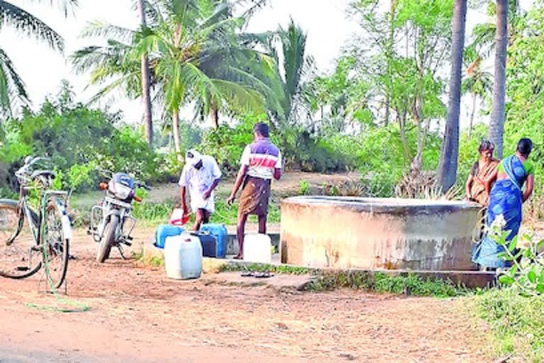 ఊటబావిలో నీటిని తోడుతున్న గ్రామస్థులు