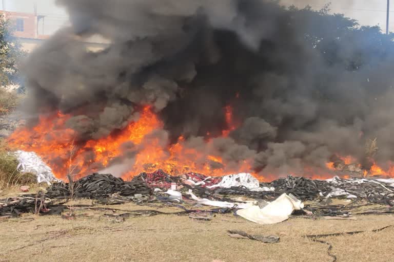 Factory worker burning garbage in large industrial area sonipat