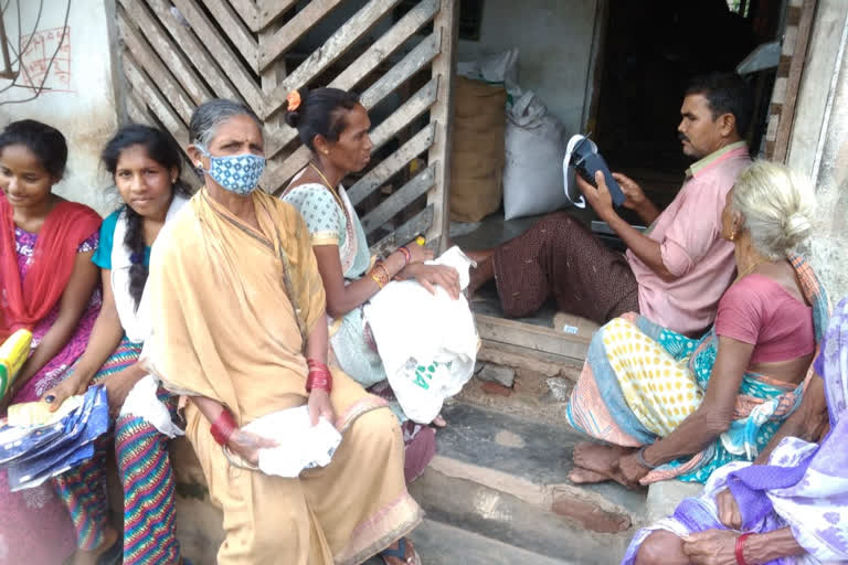 people waiting for ration goods at que in madugula