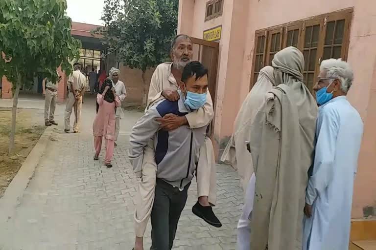 Son arrives at booth by taking his elderly father on shoulder in baroda