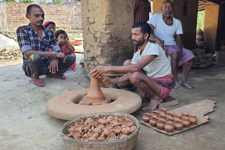 चाक से दीये बनाता कुम्हार