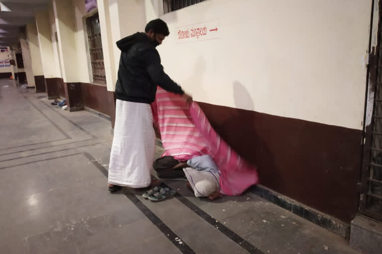 a man  distribute blankets to orphans in raichur