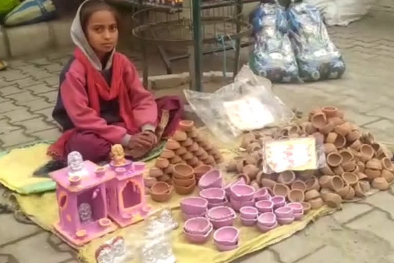 Seven year old girl is selling diyas in tohana