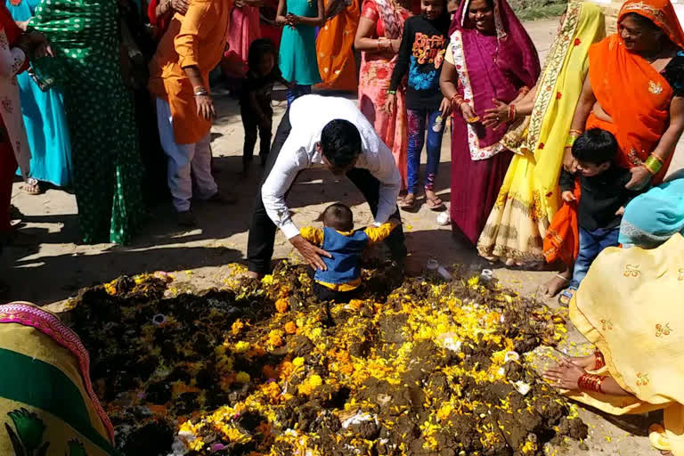 Tradition of putting young children on cow dung in betul