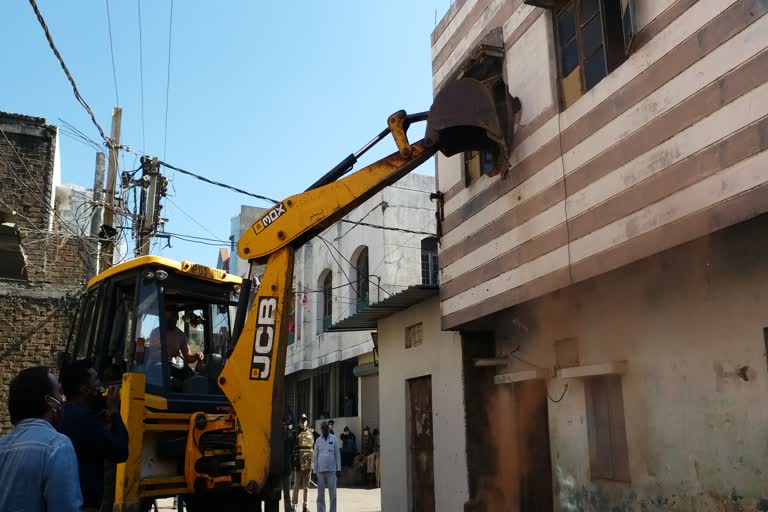 Bulldozer on house