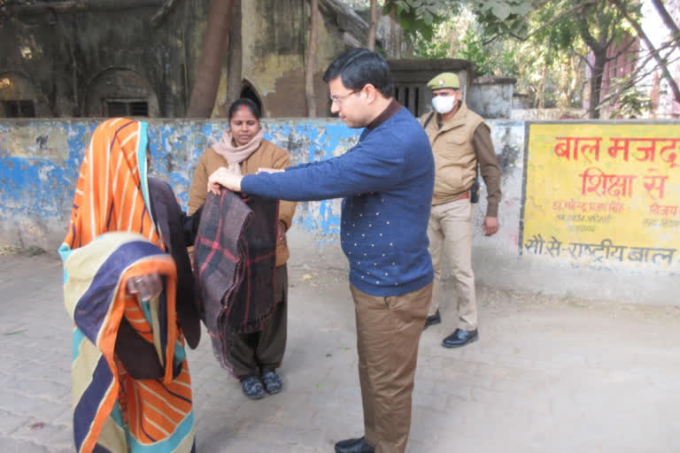 बुजुर्ग महिला को कंबल ओढ़ाते डीएम.