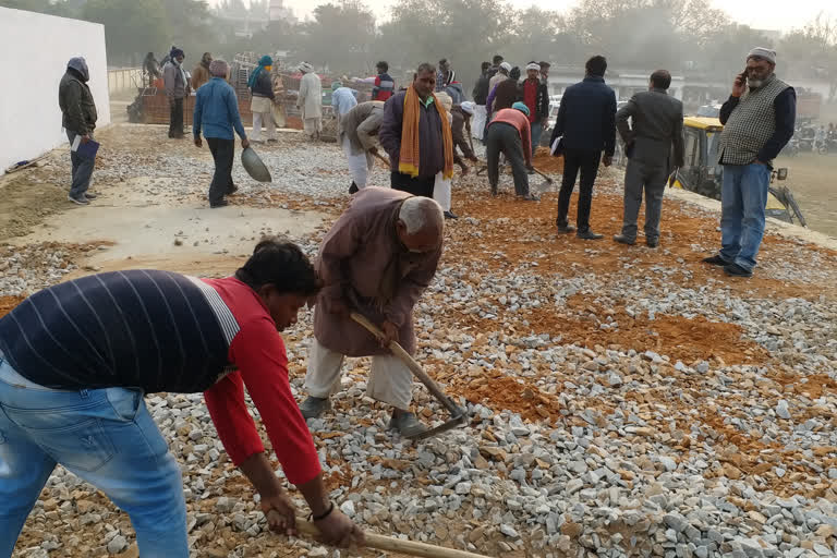 ग्राउंड की मरम्मत करते कर्मचारी.