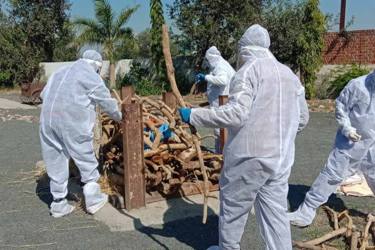 Daughter cremated father wearing PPE kit