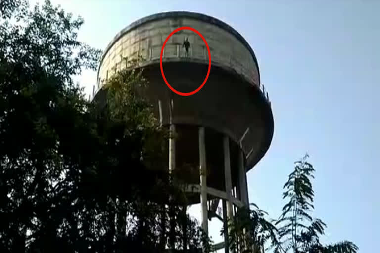 A young man climbing a water tank