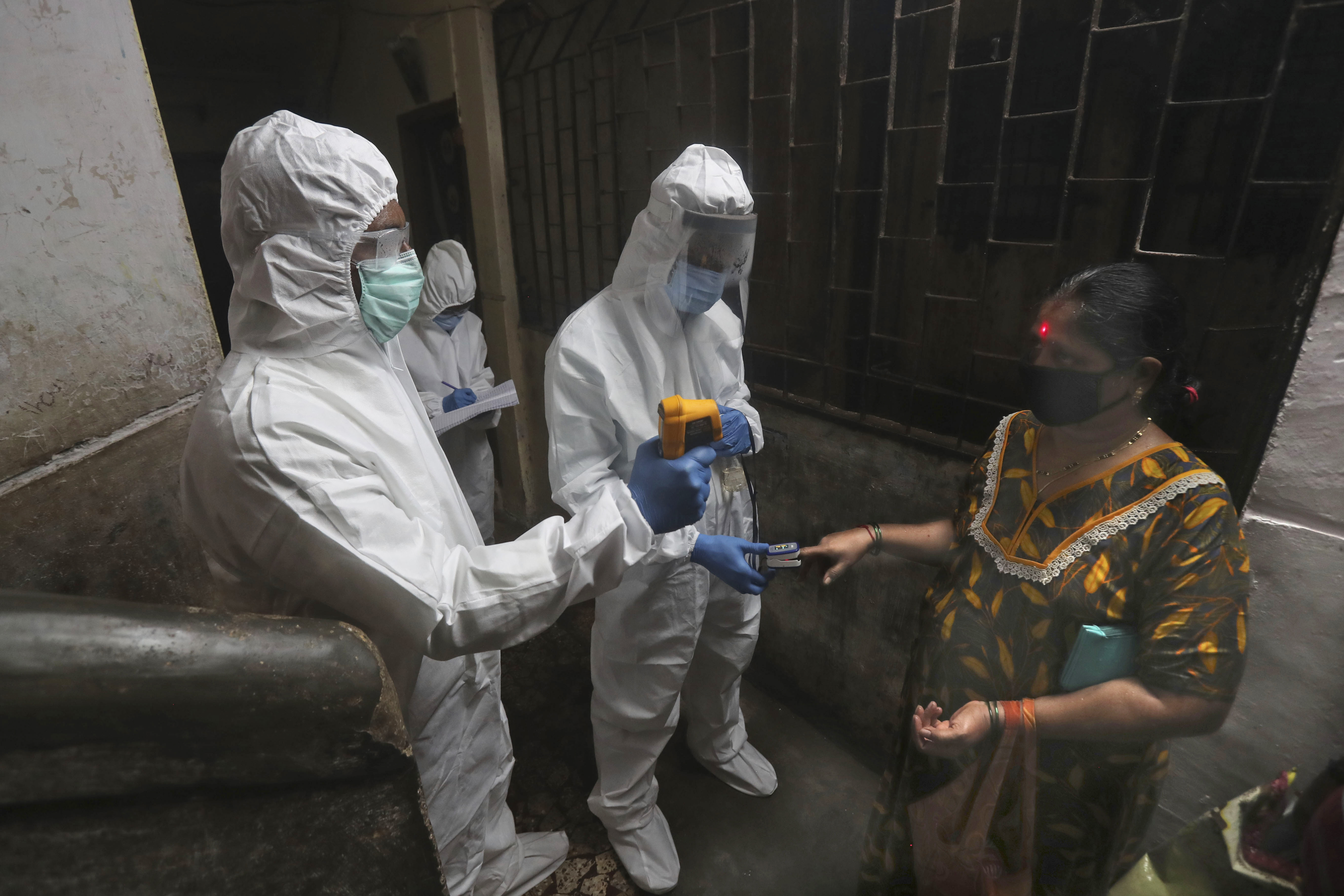 Health workers screen people for COVID-19 symptoms at a residential building in Dharavi, one of Asia's biggest slums, in Mumbai, on Friday.