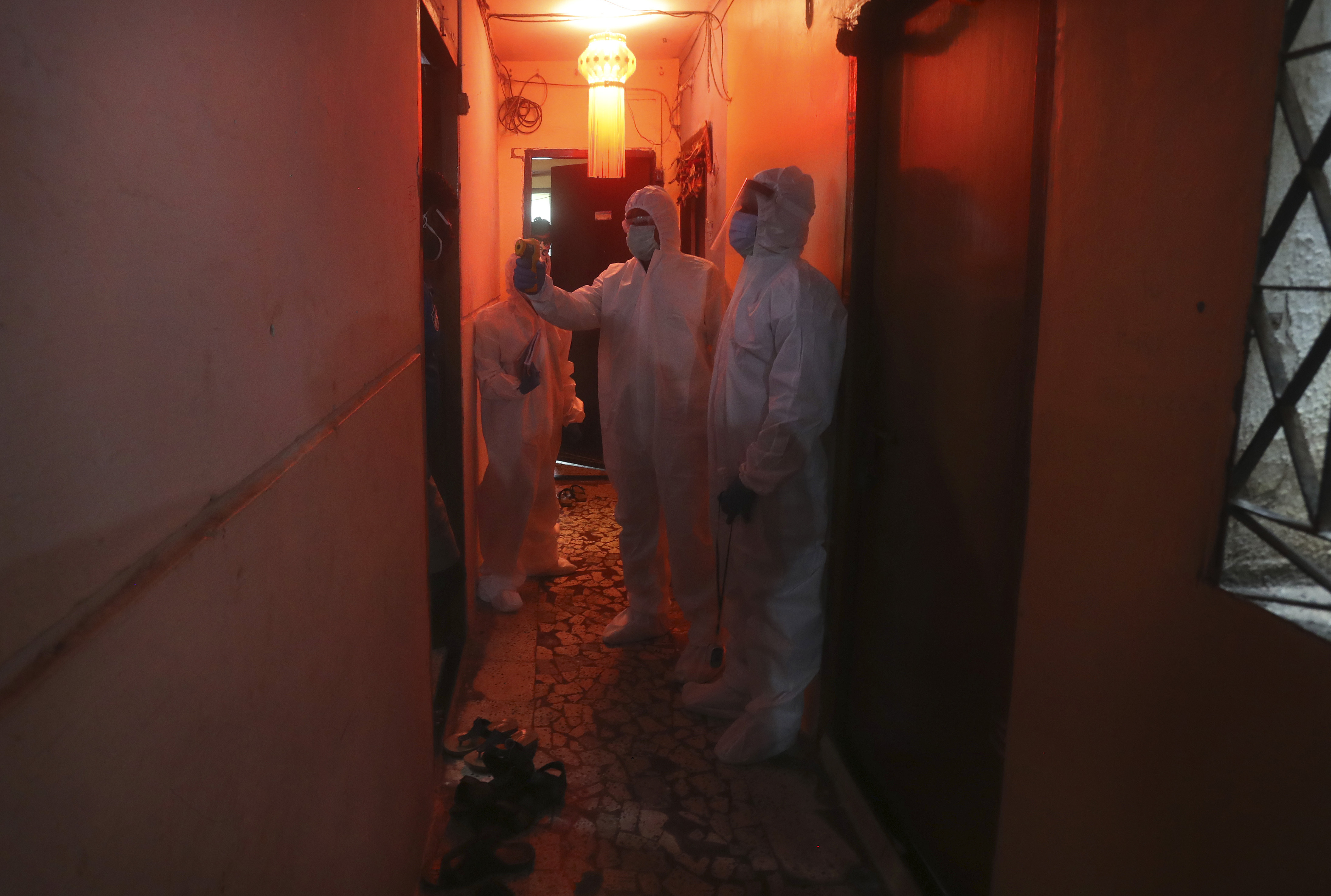 Health workers screen people for COVID-19 symptoms at a residential building in Dharavi, one of Asia's biggest slums, in Mumbai, on Friday.