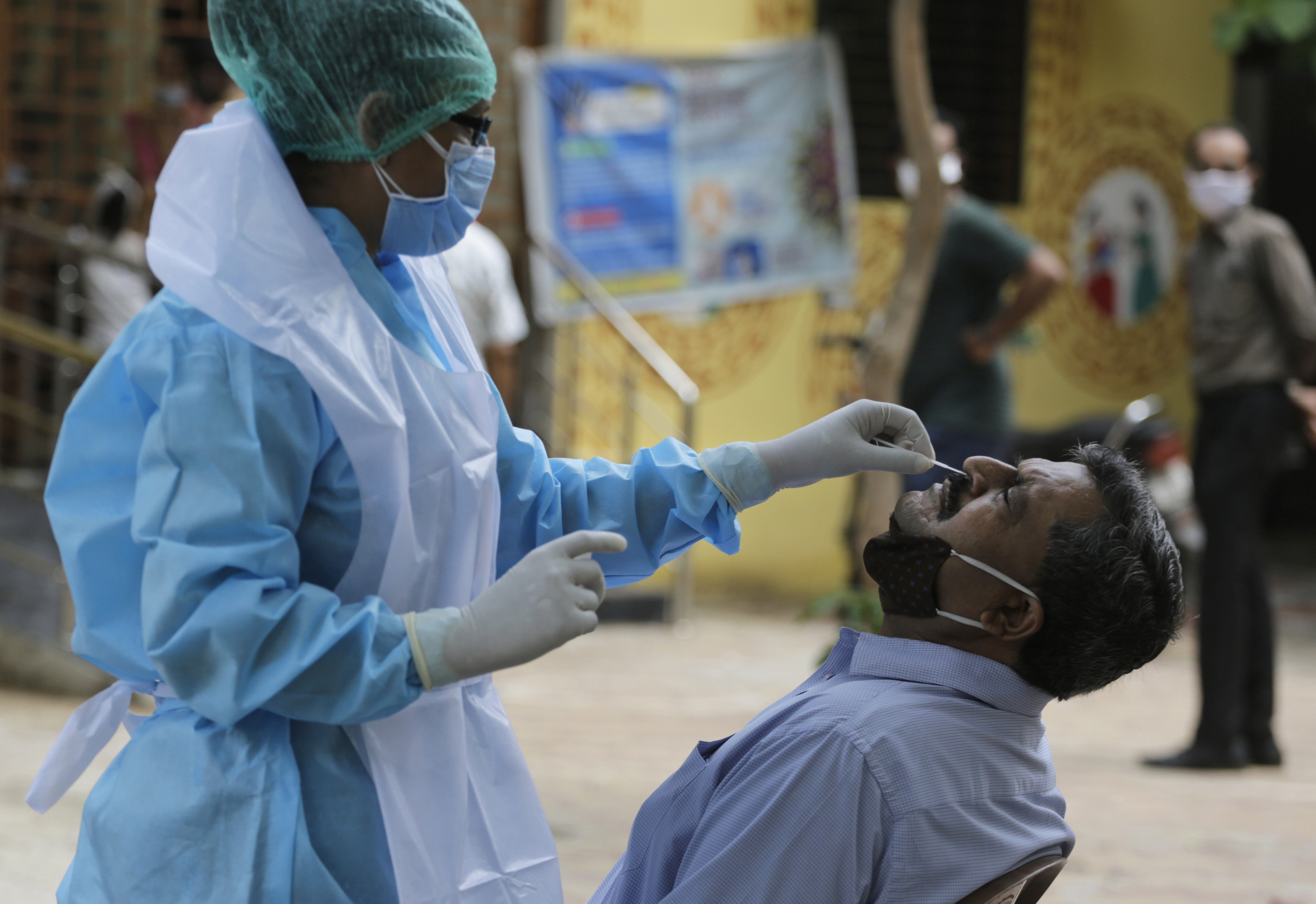 A health worker takes a nasal swab sample of a man at an urban health centre in Ahmedabad, on Thursday.