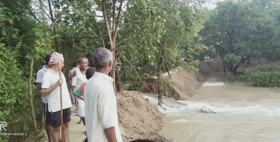 टूटे बांध को देखते लोग