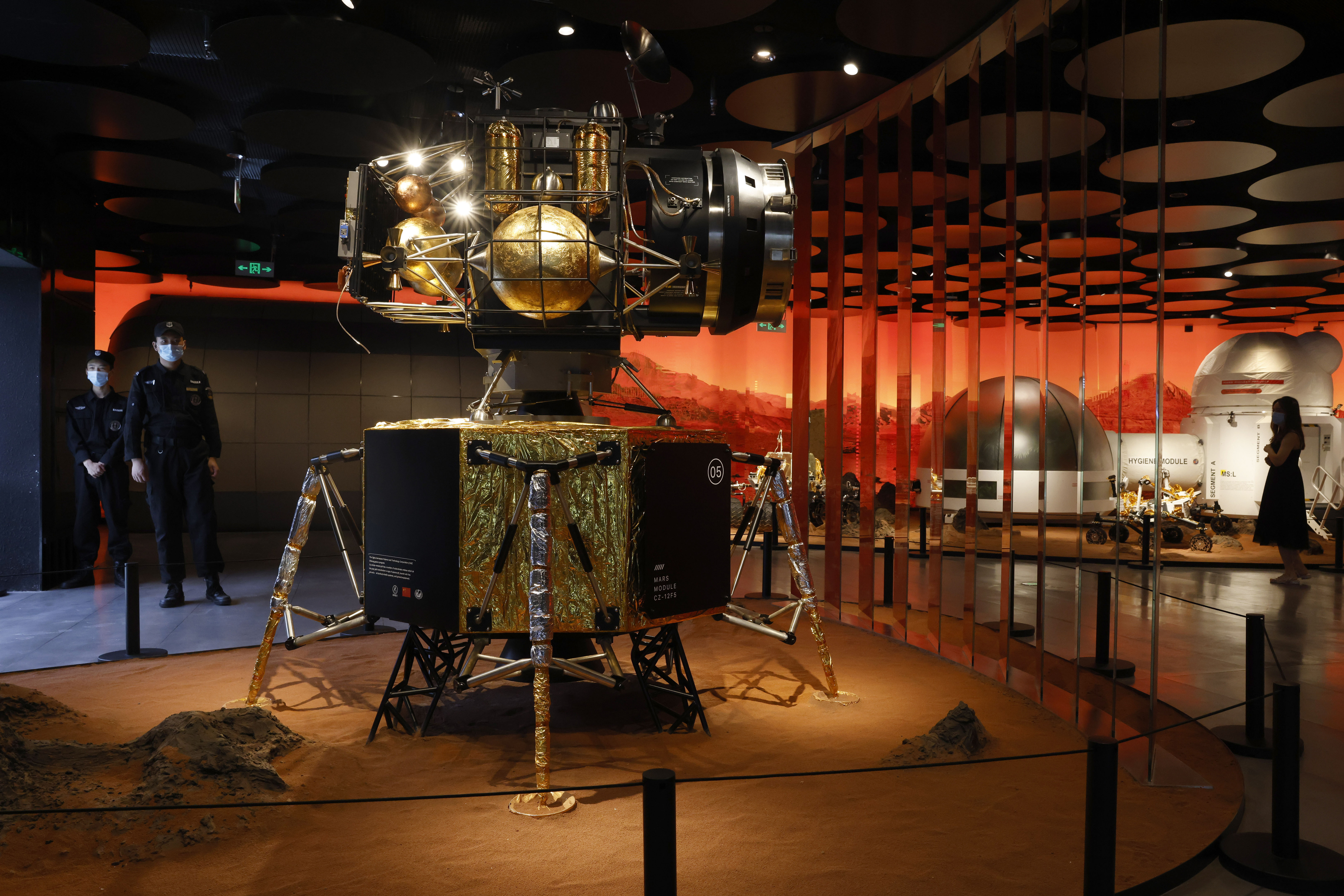 Security guards stand near a model of a landing capsule for Mars at an exhibition in Beijing on Thursday.