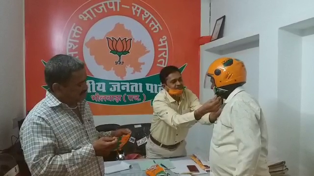 BJP officials distributing mask-helmets to energize workers