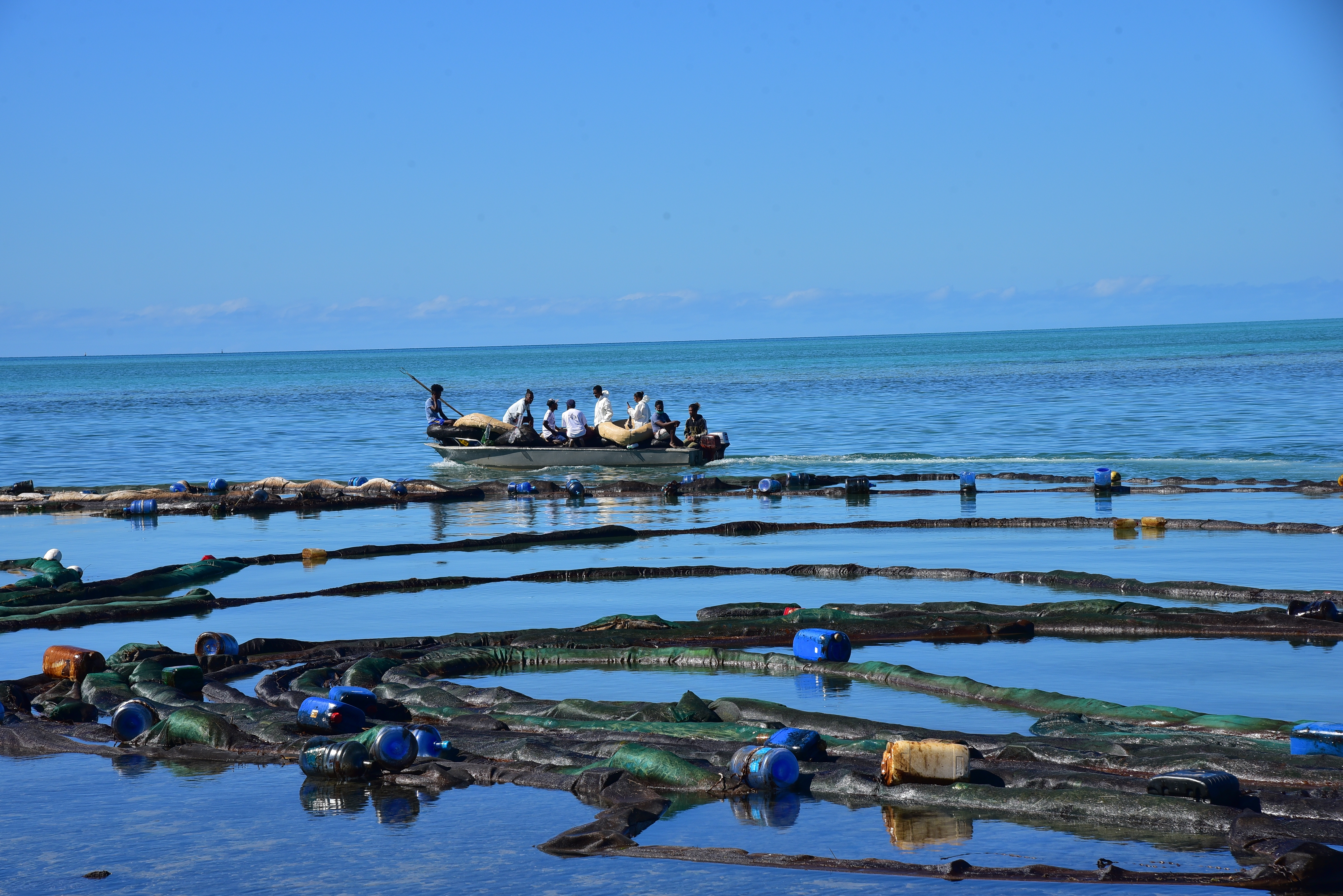 Volunteers take part in the clean up operation in Mahebourg, Mauritius, Wednesday, surrounding the oil spill from the MV Wakashio, a bulk carrier ship that recently ran aground off the southeast coast of Mauritius.