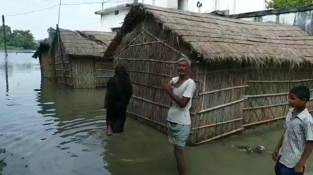 बाढ़ के पानी में लोग