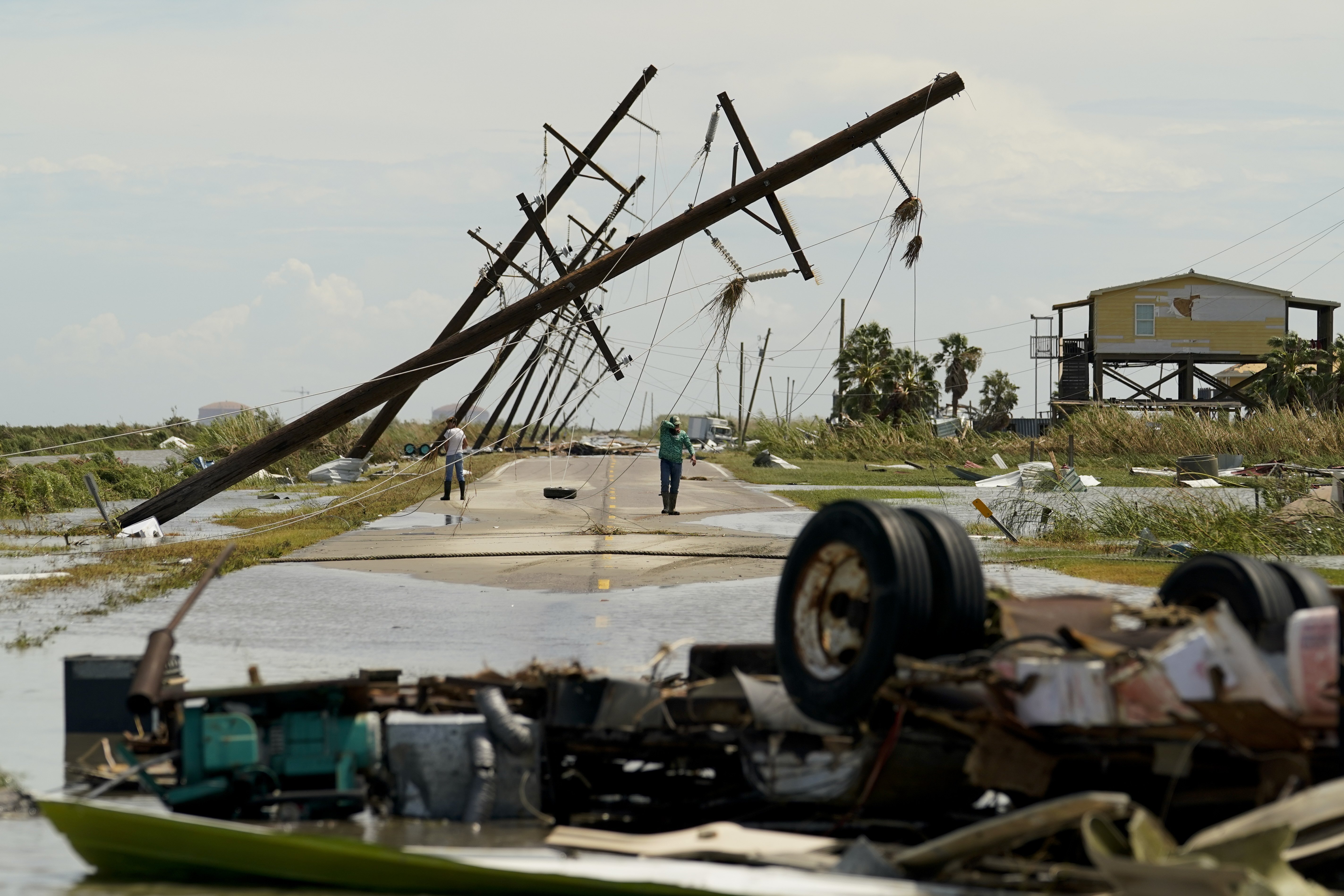 People survey the damage left in the wake of Hurricane Laura on Thursday in Holly Beach.