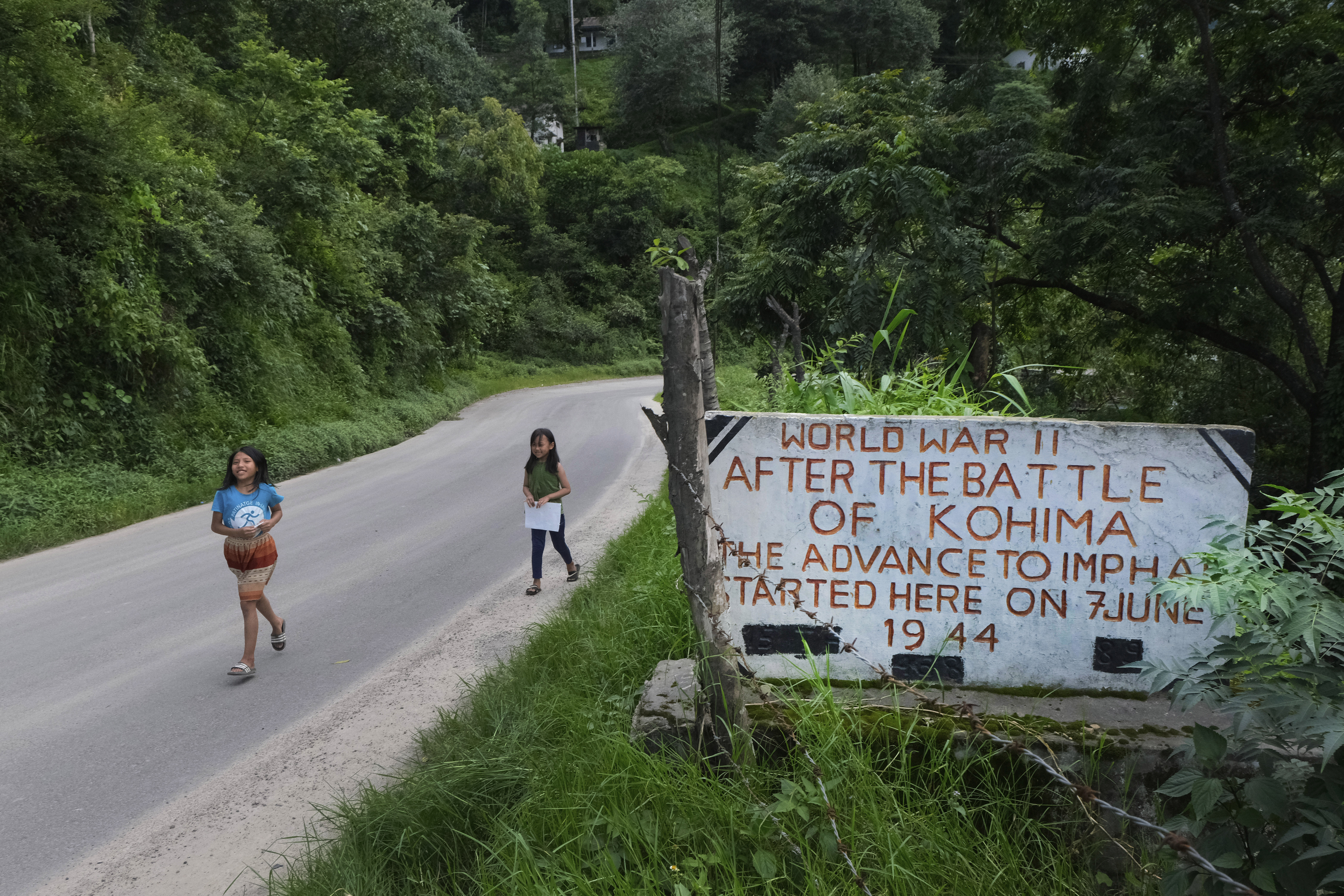 Angami Naga girls walk past a World War II plaque on the Imphal-Kohima highway on the outskirts of Kohima. (File pic)