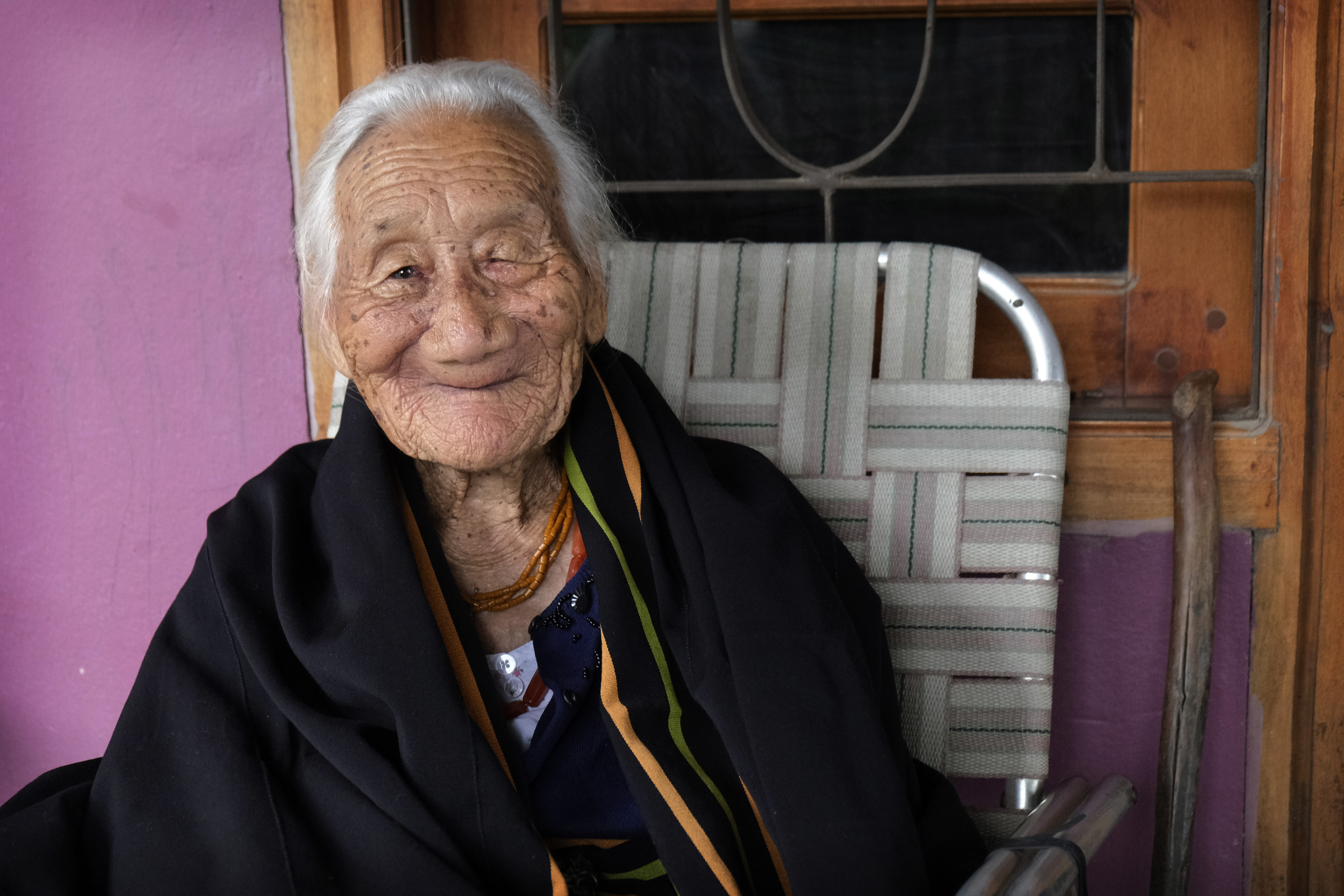 Kuou Kesiezie, a 108-year-old Angami Naga survivor of the Battle of Kohima fought between the Japanese and British Commonwealth forces in and around her village, smiles as she sits outside her daughter's house in Kohima. (File)