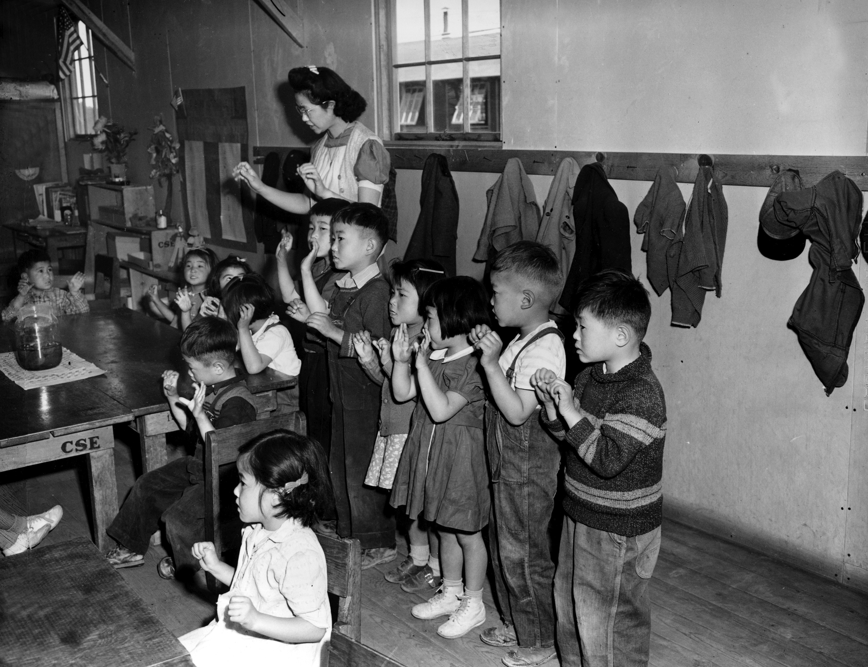 Aiko Sumoge, an assistant teacher, leads a Kindergarten class to sing an English folk song at the internment relocation center for Japanese Americans in Tule Lake, Ca., in during World War II. (FILE)