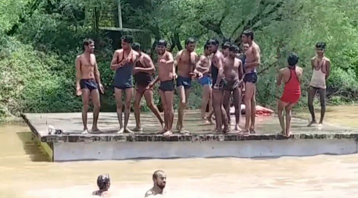 People leaping in flooded Narmada