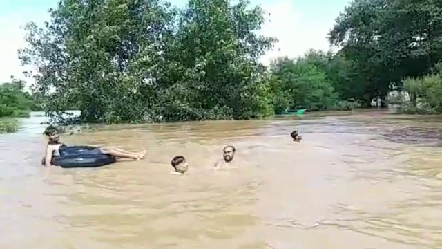 People leaping in flooded Narmada