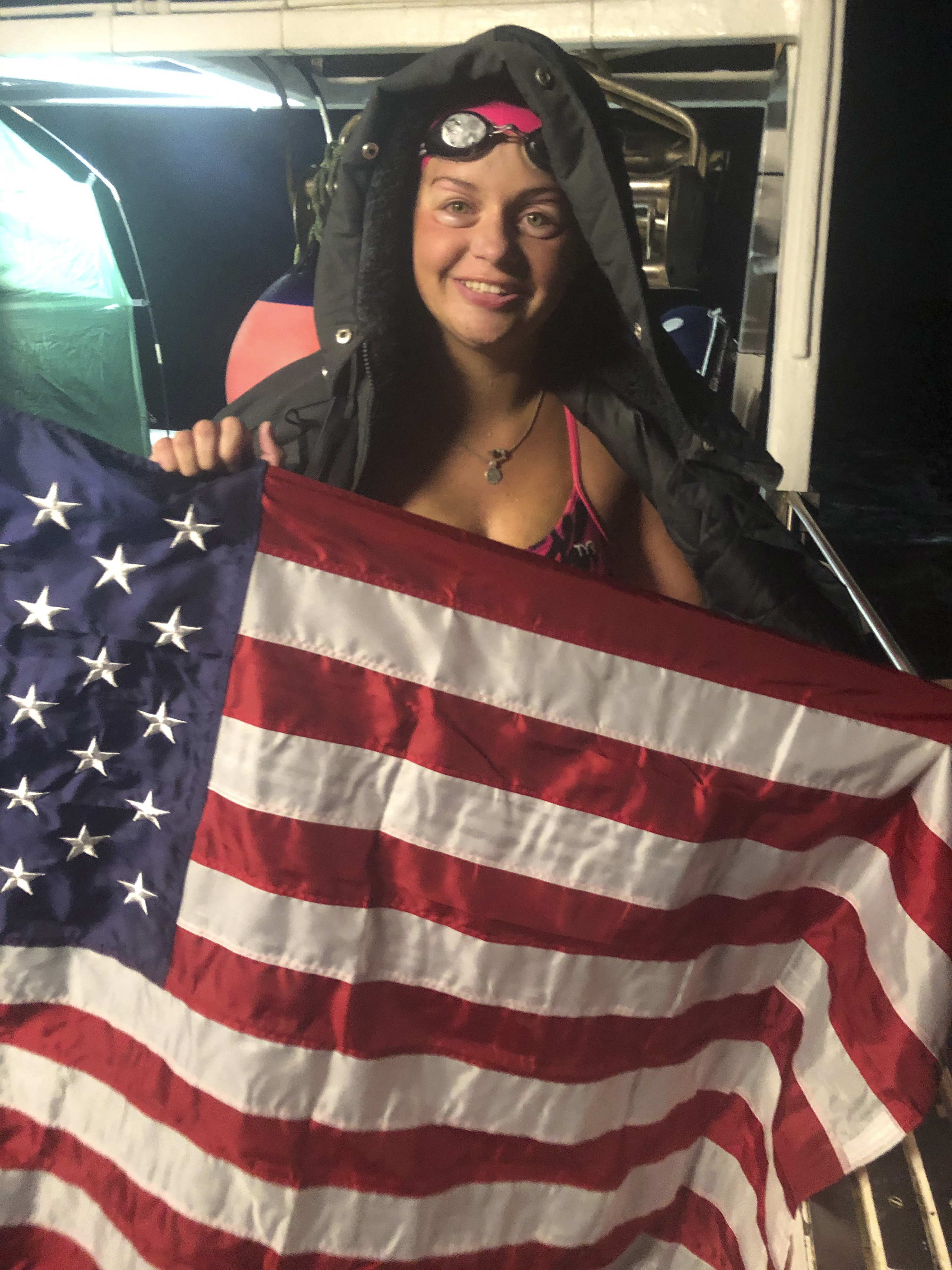 Vera Rivard of Springfield, N.H., displays an American flag while aboard a vessel off the coast of France, late Tuesday, after swimming the English Channel between Dover, England, and Calais, France.