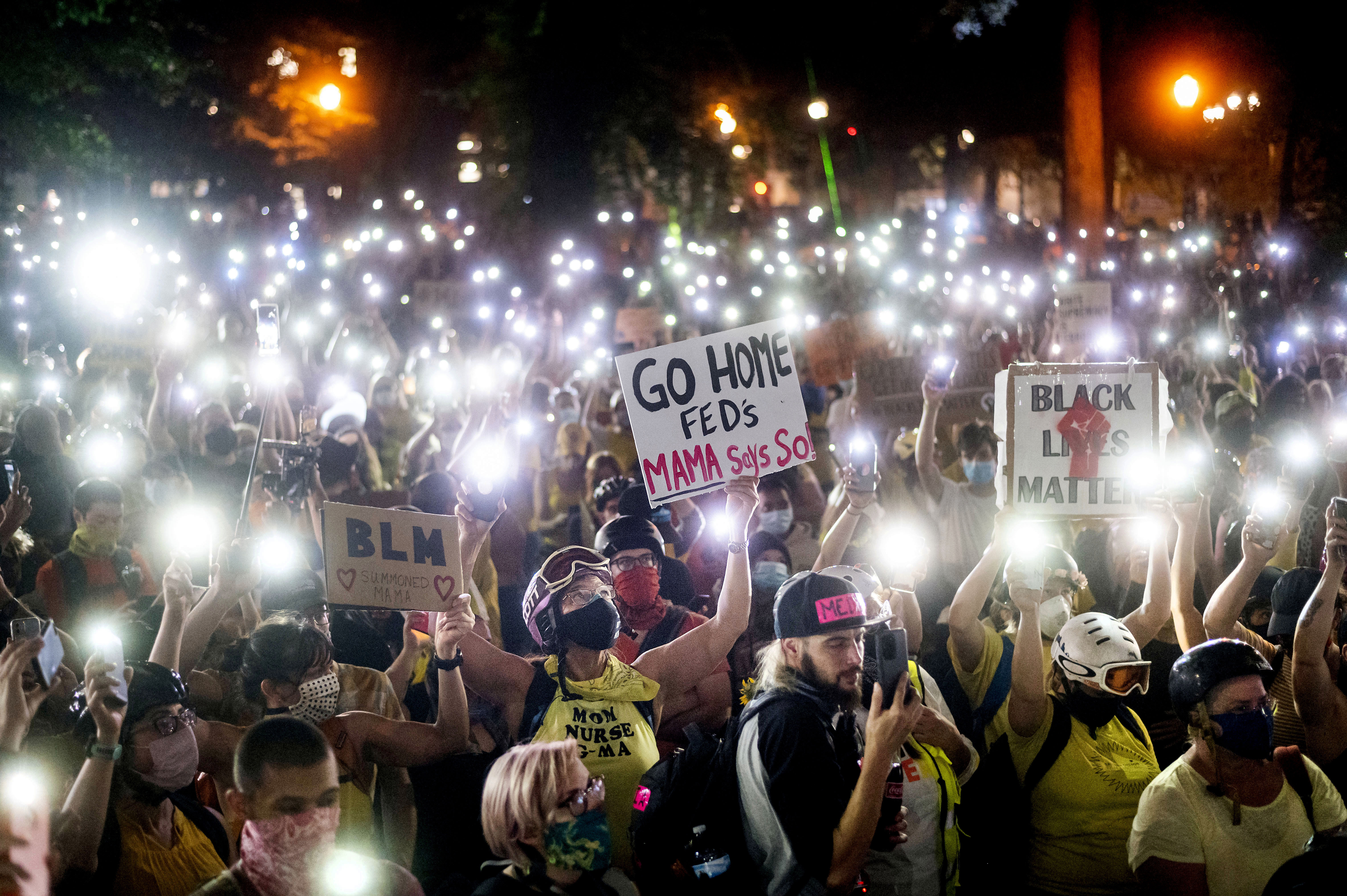 In this July 20, 2020, file photo, hundreds of Black Lives Matter protesters hold their phones aloft in Portland, Ore.