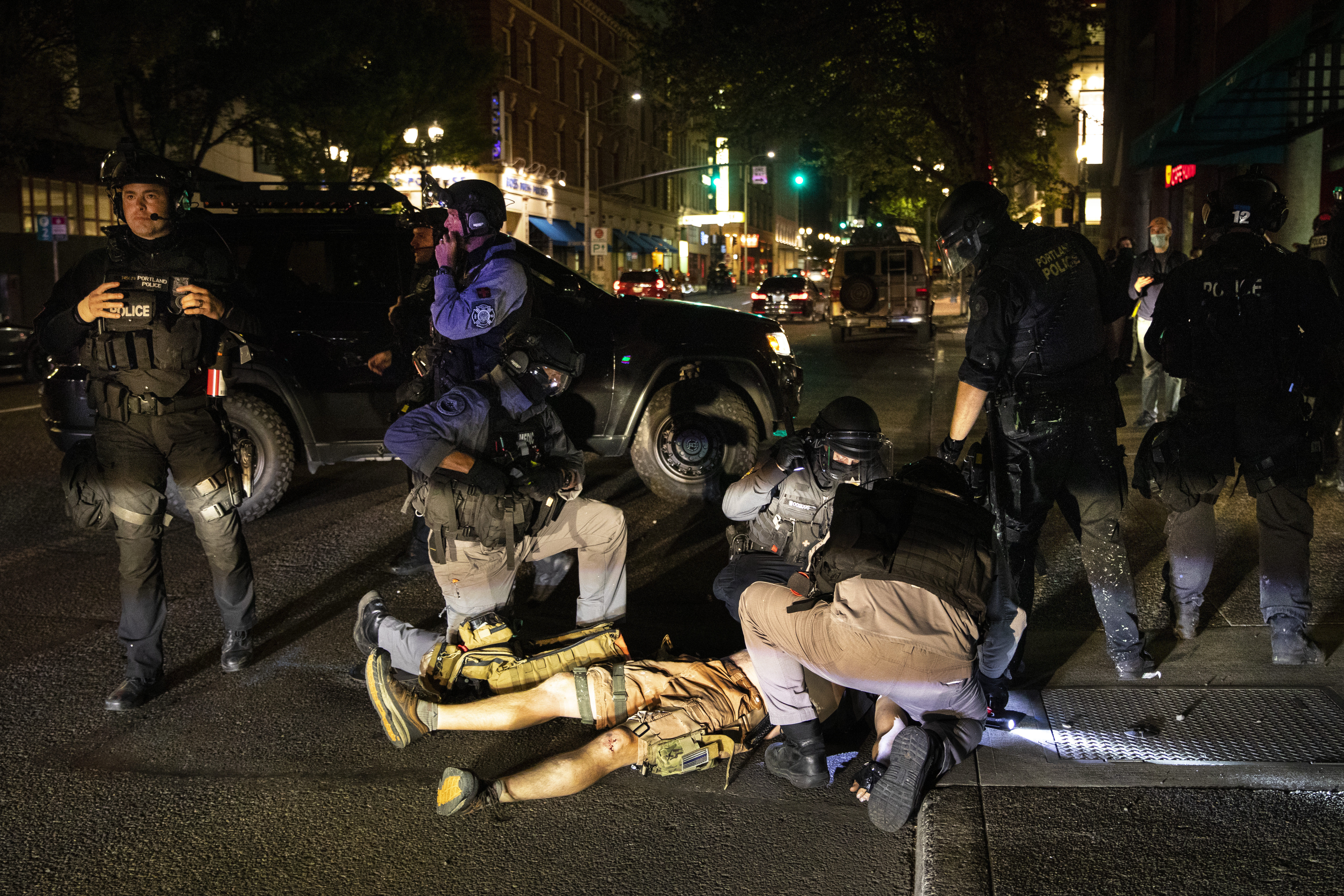 In this Aug. 29, 2020, file photo, a man who later died is treated after being shot at a demonstration in Portland, Ore.