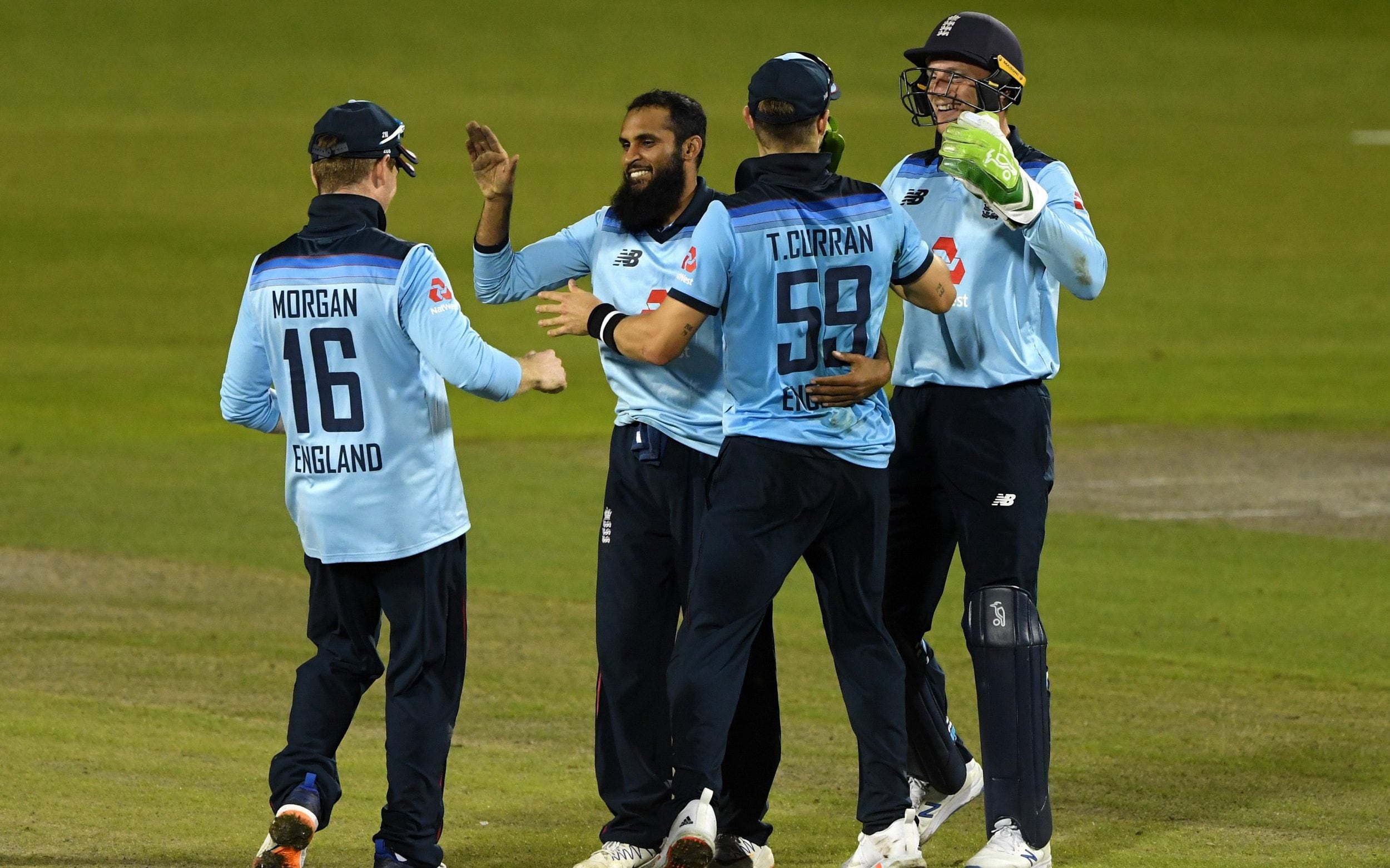 Adil Rashid celebrates with England cricketers after taking the wicket of Alex Carey.