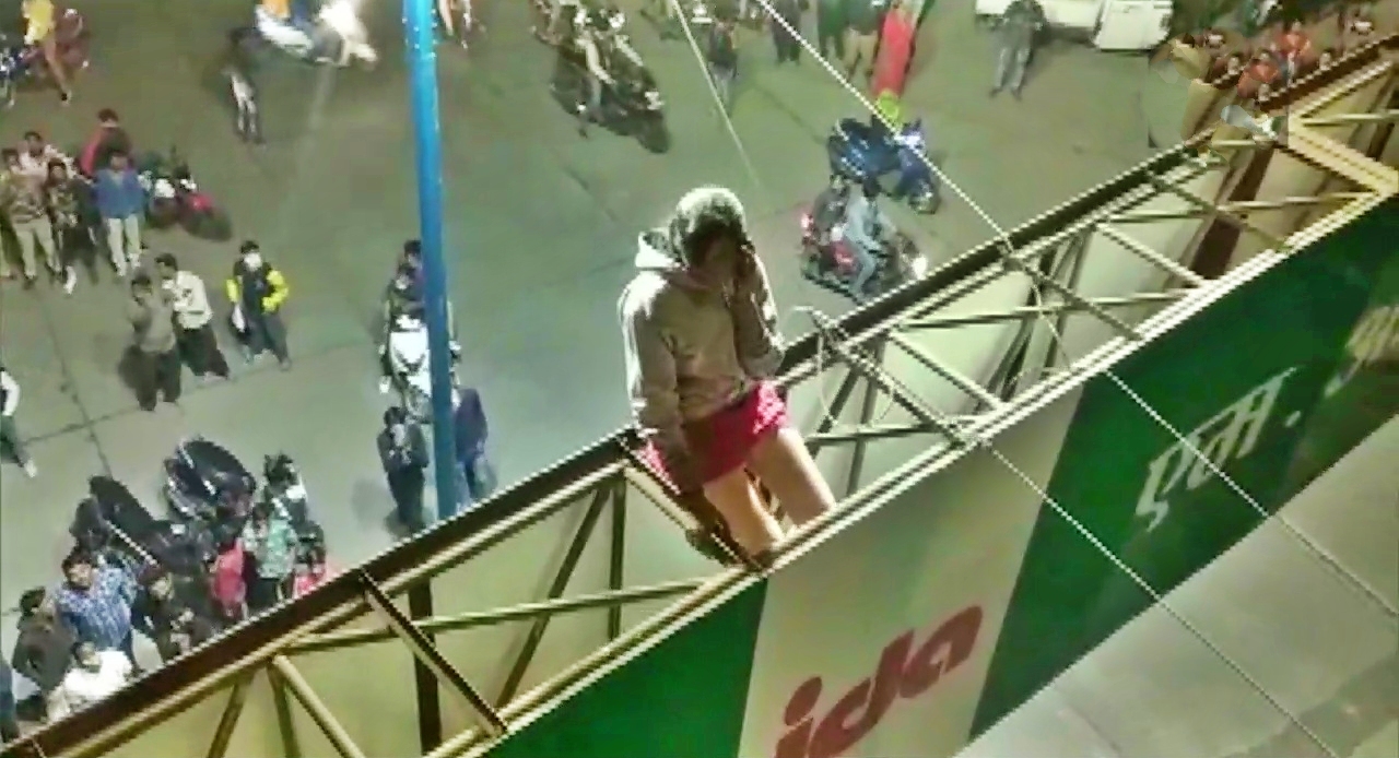 A girl climbed atop a hoarding at Bhandari Bridge in Indore's Pardesipura