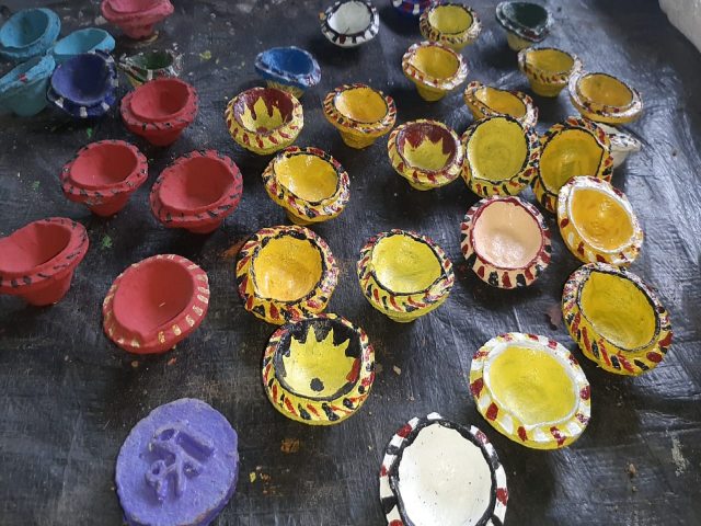 Women making diya of cow dung