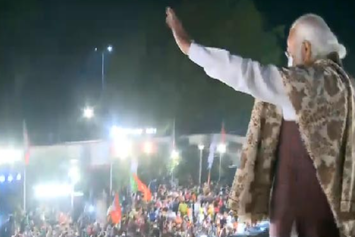 Modi shows victory sign and waves at the BJP workers